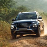 2025 Hyundai Venue driving on uneven Indian rural road showing 195 mm ground clearance and suspension movement